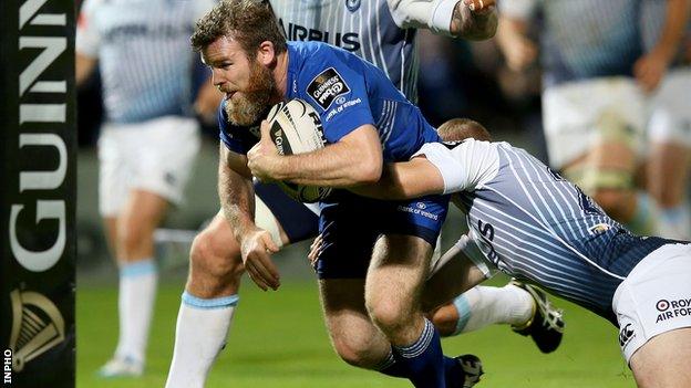 Gordon D'Arcy charges through to score Leinster's third try despite the tackle from Dan Fish