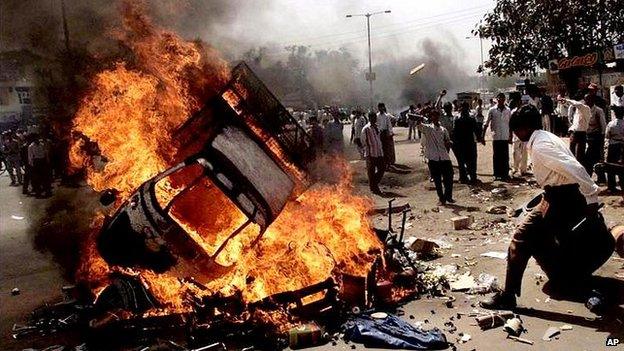 A vehicle burns in Ahmedabad, India, 28 Feb 2002