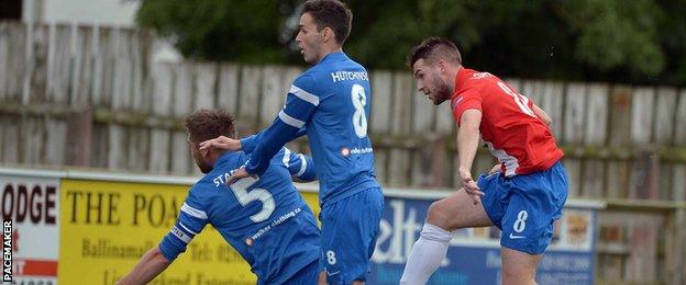 Linfield's Stephen Lowry beats Mark Stafford and Stuart Hutchinson of Ballinamallard United