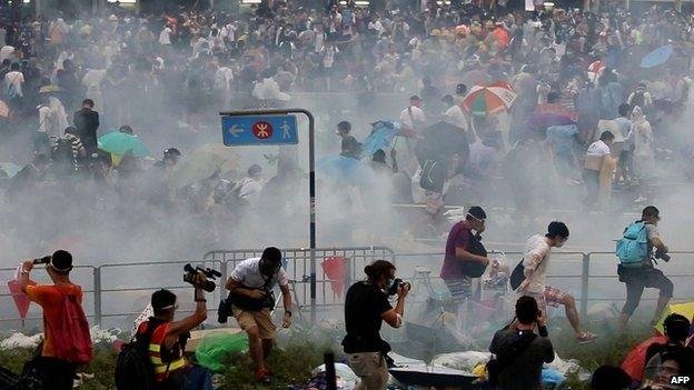 People disperse after police fired tear gas upon pro-democracy demonstrators near the Hong Kong government headquarters on 28 September 2014.