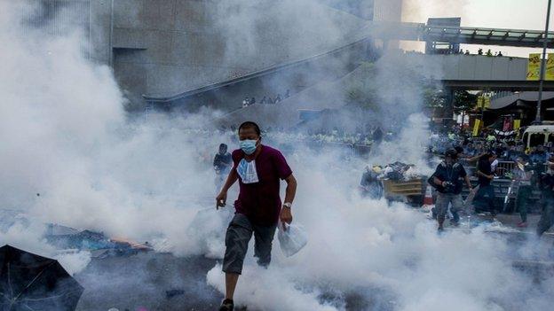 A pro-democracy demonstrator runs as police fired tear gas towards protesters near the Hong Kong government headquarters on 28 September 2014.