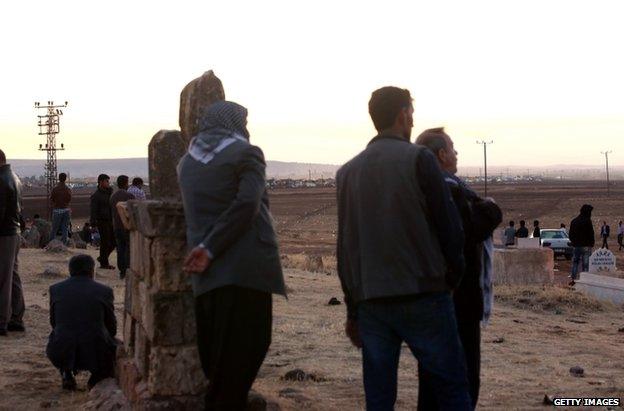 Turkish residents at Suric look across the border into Syria as fighting continues, 28 September