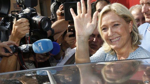 French far-right leader Marine Le Pen waves as she leaves after addressing a youth summer congress of the Front National (FN) far-right party , on 7 September 2014, in Frejus, southern France