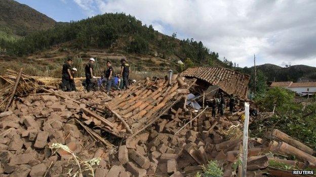 Rescue workers remove debris at a street in Paruro after an earthquake hit on 28 September, 2014