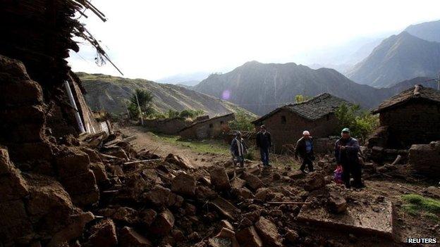 Rescue workers remove debris at a street in Paruro after a quake hit on 28 September, 2014.