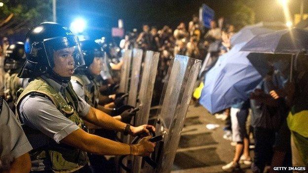 Police officers trying to defend Hong Kong's government complex from protesters on 27 September 2014