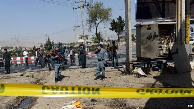 Afghan policemen stand guard at the site of a suicide attack near the international airport in Kabul on September 29, 2014.