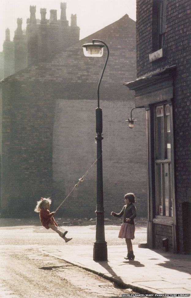Two girls swing on a lamppost, Manchester 1965