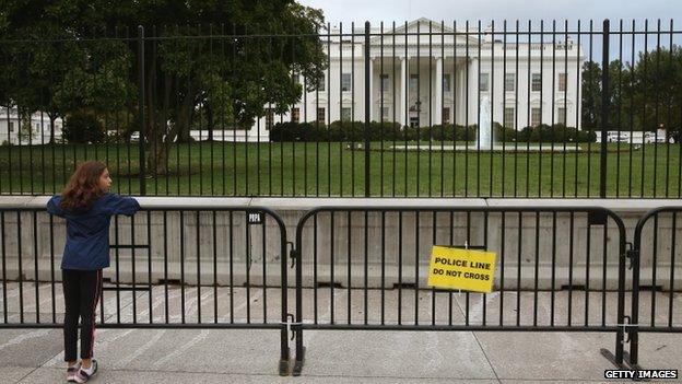 A young girl stands at a added security fence outside of the White House on 25 September 2014