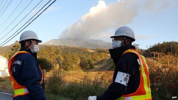 Security guards stand at the entrance of a road leading to the mountain trail of Mount Ontake in Nagano prefecture on 30 September 2014