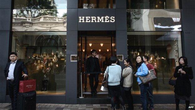 This picture taken on 20 January 2014 shows tourists queuing in front of a luxury shop in a popular shopping district in Hong Kong.