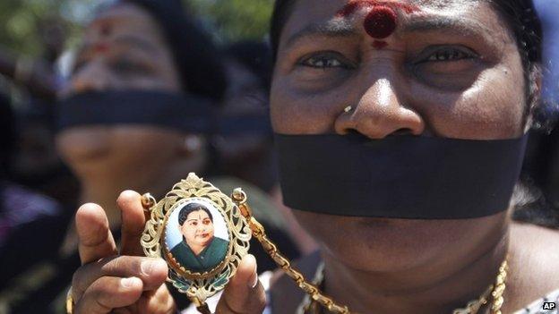 A supporter displays a pendant with a picture of Jayaram Jayalalitha at a protest against jailing of their leader in Chennai, India, Sunday, Sept.28, 2014