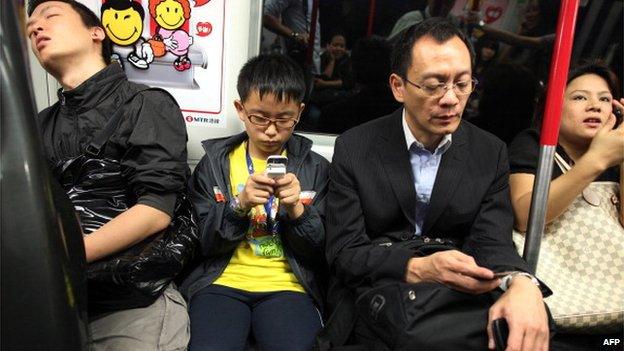 Passengers sit on the Mass Transit Railway (MTR) in Hong Kong on 15 November 2010.