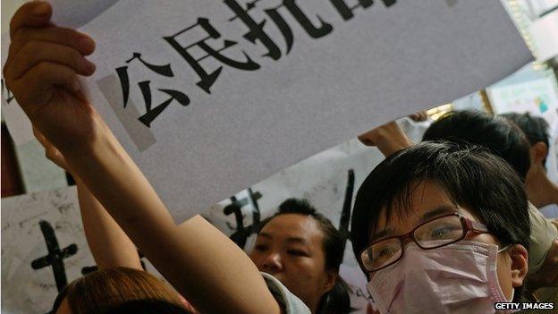 A student protester displays a placard reading "citizen disobey orders" during a protest at the lobby of the Hong Kong office in Taipei on 29 September 2014