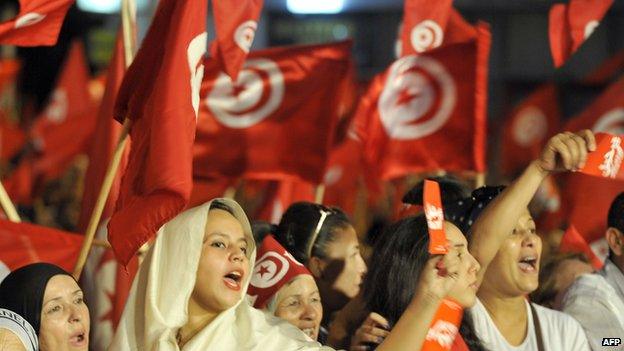 Tunisian demonstrators shout slogans and wave their national flag in front of Constituent Assembly headquarters in Tunis - 13 August 2013