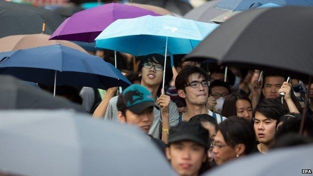 Protesters clutch umbrellas, a symbol of the ongoing protests on 1 Oct