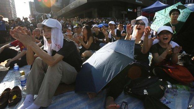 Protesters applaud as they listen to speeches in Hong Kong on 1 Oct