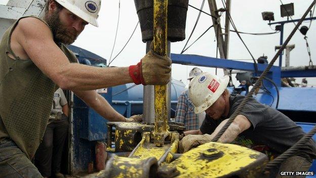 Two men operate an oil rig in Illinois.