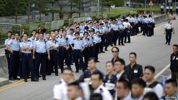 Police officers gather as protesters block the entrance to Hong Kong Chief Executive CY Leung's offices in Hong Kong on 2 October 2014