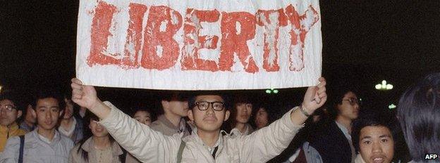 A student displays a banner with one of the slogans chanted by the crowd in Tiananmen Square on 22 April 1989