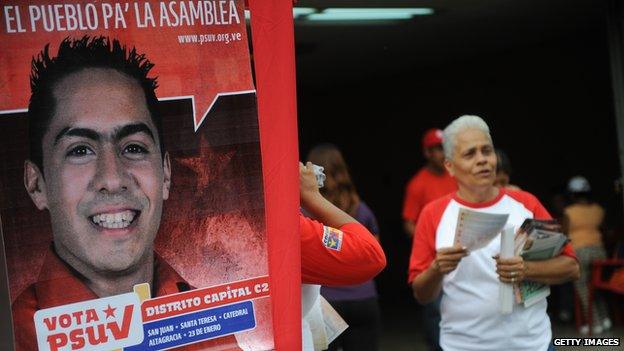 A woman stands next to a poster of Robert Serra on 22 September, 2010