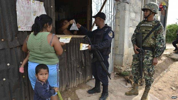 Residents watch information released by a joint patrol of marines, army, ministerial policemen and relatives of young that went missing during weekend clashes in Iguala, Guerrero state, Mexico on October 1, 2014