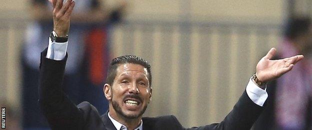 Diego Simeone raises both hands reacting to a decision in Atletico Madrid's Champions League match against Juventus