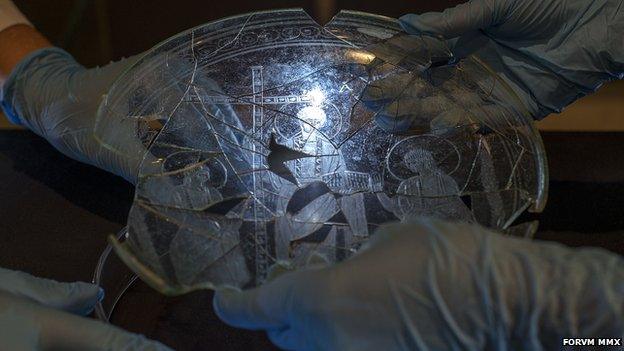 Hands holding an ancient plate