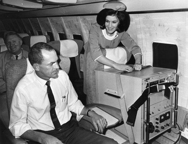 Two first class seats aboard a TWA jet from London to Washington. One occupied by a caesium beam timepiece accurate to one-millionth of a second used in the USA's space programme. This clock is being returned to America from South Africa and as it must not be allowed to stop it is connected to a power point in the aircraft during the flight. The other seat is occupied by one of the clock's escorts