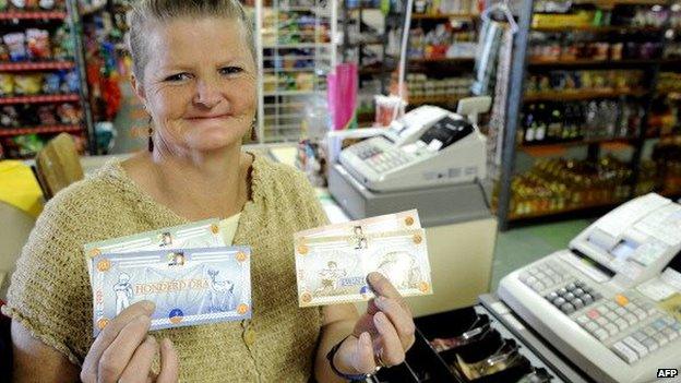 A woman holding Ora notes in Orania, South Africa