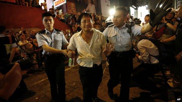 Policemen lead a man away from a protest site in Hong Kong. Photo: 4 October 2014