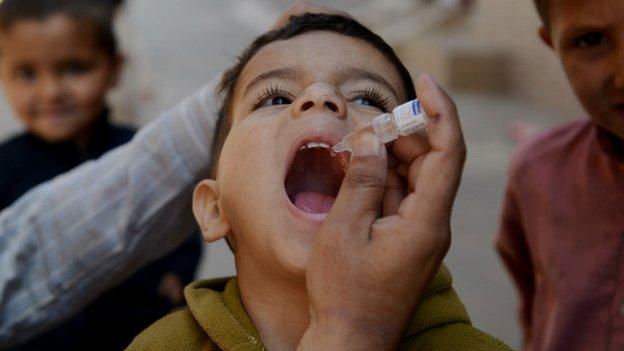 A Pakistani child receives a polio vaccination drops from a health worker in Rawalpindi - 8 April 2014