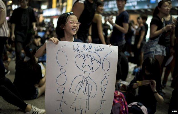 A girl holds a sign she drew herself of CY Leung 1 October 2014