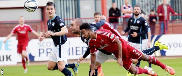 James McPake heads into his own net under pressure from Shay Logan