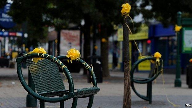 Benches and trees with yellow ribbons tied to them