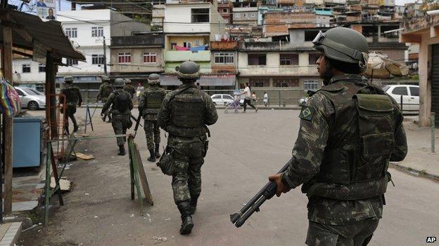 Soldiers patrol the alleys of the Mare Complex slum during general elections in Rio de Janeiro, Brazil, Sunday, Oct. 5, 2014