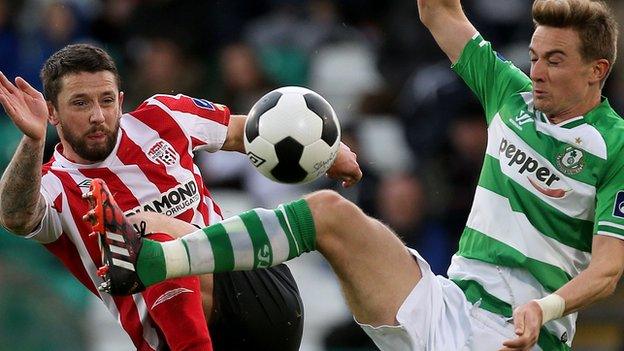 Rory Patterson of Derry goes for the ball with Ronan Finn of Shamrock Rovers