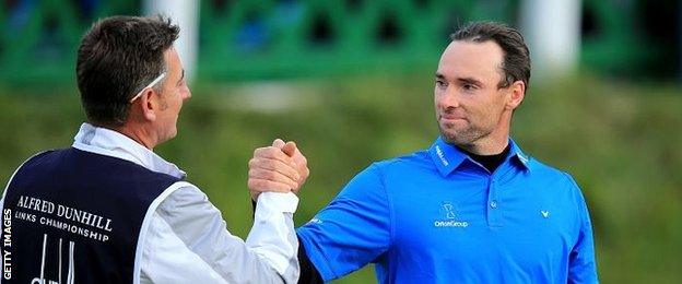 Oliver Wilson of England is congratulated by his caddie John Dempster