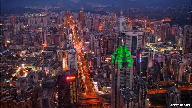 The Shenzhen skyline, including The Shenzhen World Financial Center, illuminated by green lights, stretches in to the distance on 28 November, 2010 in Shenzhen, China