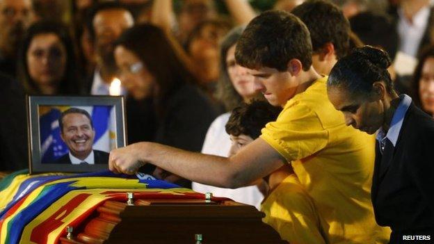 The sons of the late Brazilian presidential candidate Eduardo Campos touch the coffin containing his remains as his running mate Marina Silva reacts during his wake in Recife on 17 August 17, 2014