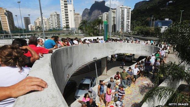 Brazilians wait in line to enter a polling station in the Rocinha favela, or community, on the day of national elections