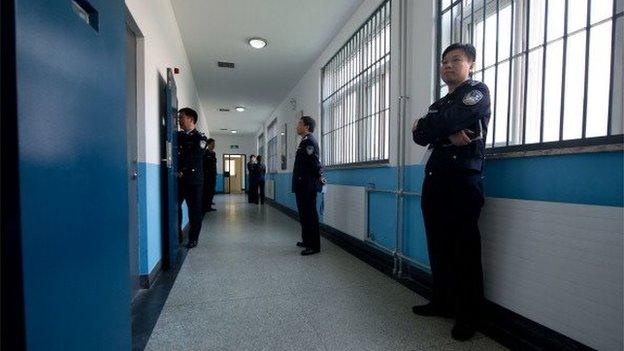 Police guards stand in a hallway inside the No. 1 Detention Centre during a government guided tour in Beijing on 25 October 2012.