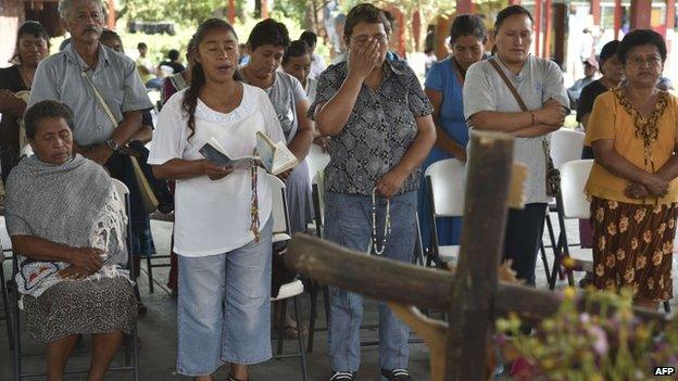 Parents of killed or missing students pray in front of an altar in Ayotzinapa