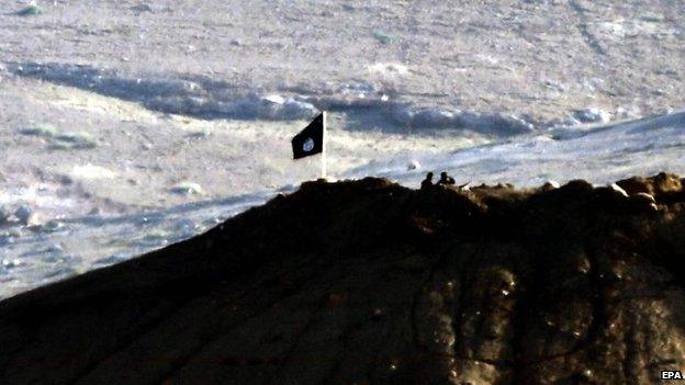 The view of an IS flag from the Turkish side of the border near Kobane, 6 Oct