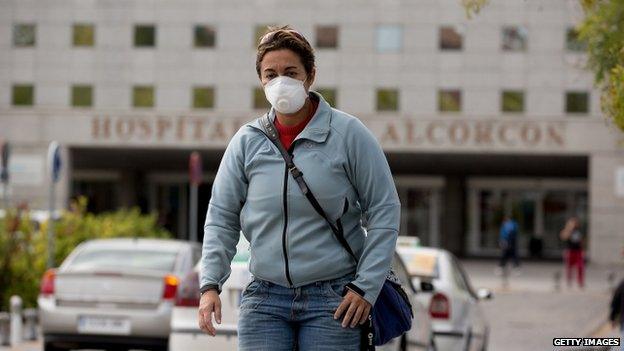 A woman wears protective mask as she leaves Alcorcon hospital on 7 October 2014