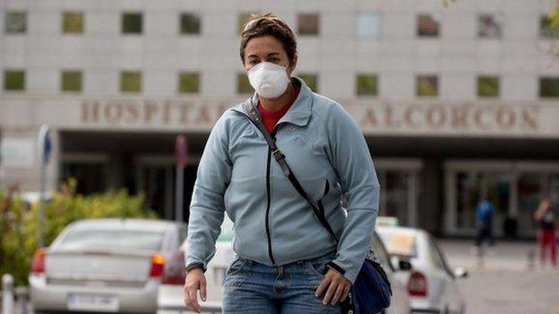 A woman wears protective mask as she leaves Alcorcon hospital on 7 October 2014