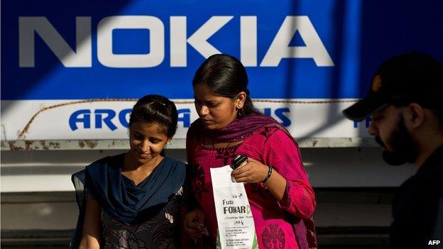 Indian women walk out of a Nokia store in New Delhi