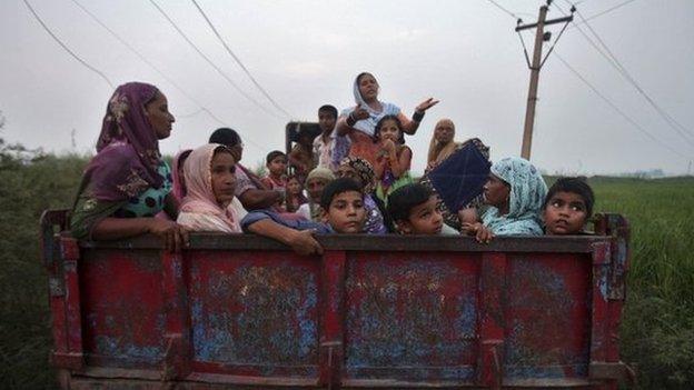 Indian villagers sit in a tractor trolley as they move to safer places at Devi Garh village near Jammu October 7, 2014.