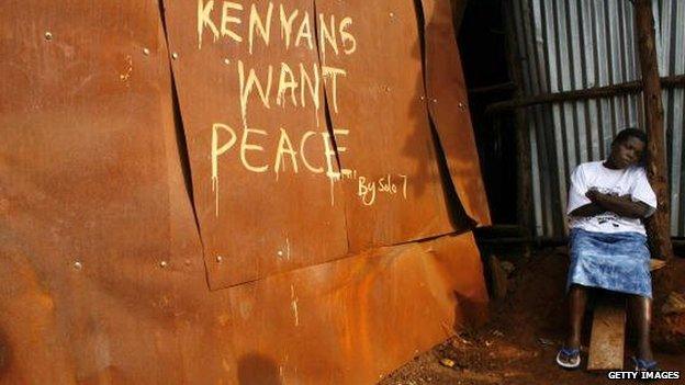 A woman rests near her shack in the Kibera slums painted with a peace statement on 10 February 2008 in Nairobi, Kenya