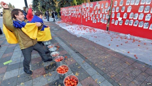 Protesters throw tomatoes at members of the Ukrainian parliament